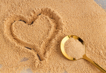 Ground organic maca in the spoon - Lepidium meyenii.