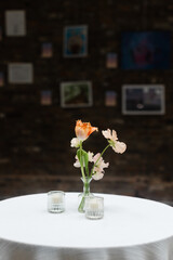 Fresh flowers adorn a table in a stylish space with art on the walls and soft lighting creating a cozy atmosphere