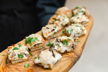 Delicious appetizers served on a wooden platter at a festive gathering in the evening