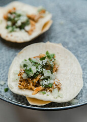 Delicious tacos served on a plate with fresh toppings during a festive gathering in a vibrant atmosphere