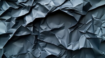 Obraz premium Crumpled gray paper texture, showcasing folds and shadows for graphic design use.