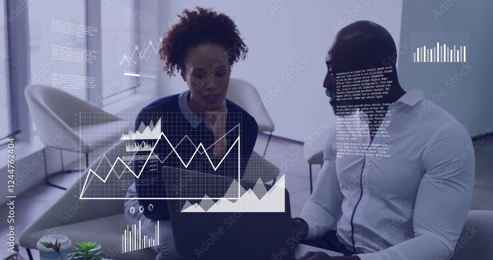Poster analyzing data on laptop, business colleagues with financial charts image over them