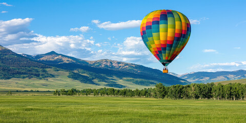 Naklejka premium Multicolored hot air balloon takes off into the sky against a picturesque mountain scenery, entertainment, balloon flight, romantic date