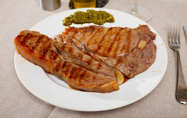 Appetizing beef entrecote served with salsa verde sauce