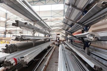 Interior view of a warehouse with stacked metal profiles
