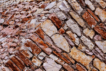 Close-up view of a textured stone wall with natural colors and varied shapes