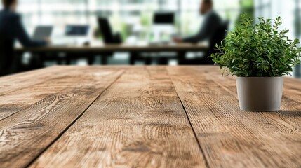 A wooden table with a potted plant in an office setting, showcasing a modern workspace.