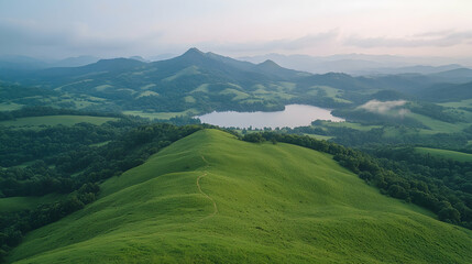 Fototapeta premium Aerial view green hills, lake, mountains, sunrise