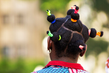 Fitas coloridas em cabelo afro. 