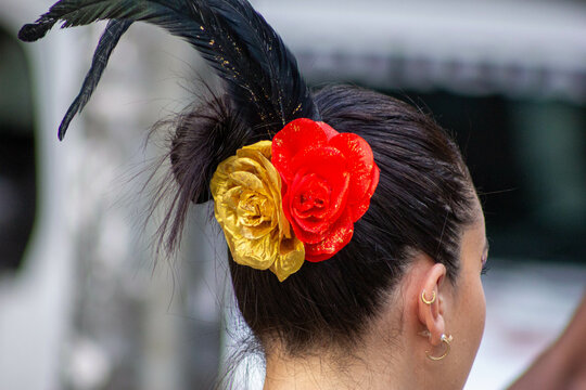 Flores de cores vermelha e preta no cabelo de mulher. 