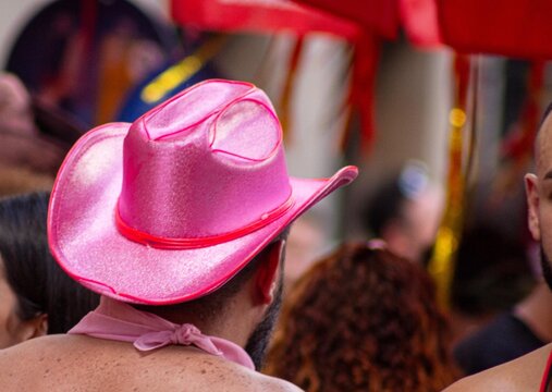 Homem de chap&eacute;u de cawboy cor de rosa em carnaval de rua de S&atilde;o Paulo.