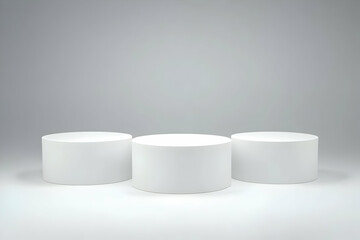 Three White Cylindrical Pedestals Stand on a White Surface Against a Gray Backdrop, Perfect for Product Display