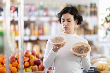 In store, woman near counter looking at yakisoba. Visitors make choice of assortment, select buy...
