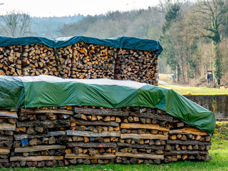 Abgedecktes und gestapeltes Brennholz im Freien © focus finder