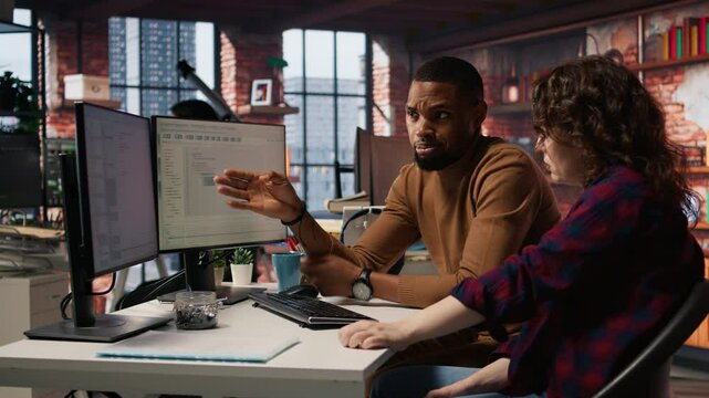 IT employees in startup office working at computer desks, testing and deploying programs and systems. Programmer and developer checking code on desktop PCs, solving tasks in workspace, camera A