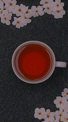 A Cup of Tea Sits Gracefully on a Dark, Glittery Surface, Adorned with Delicate White Flowers