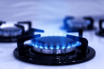 Gas burner with blue flame on stove, closeup
