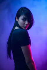 Dark hair cascades softly as light wraps around her toned silhouette