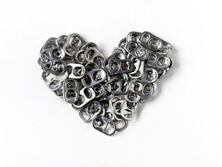 Used aluminum seals from beer can on white paper background, closeup recyclable material....