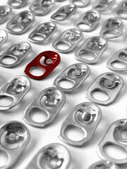 Used aluminum seals from beer can on white paper background, closeup recyclable material. Rings pull tub opener of soda or beer can