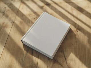 Fototapeta premium Blank Covered Hardback Book in Sunlight on a Wooden Surface for Customization and Presentation