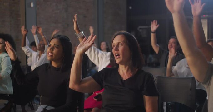 Close-up of hands raised in prayer during a church service, group of people showing devotion and unity, indoor religious gathering, spiritual atmosphere, community bonding