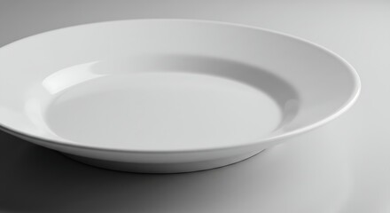 A classic white ceramic plate with a smooth surface and a slightly raised edge, perfect for serving a main course.