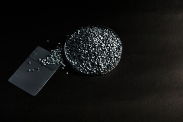 Silver color masterbatch granules in petri dish isolated on black background,color pigment carrier...