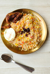 Nasi Kebuli ayam goreng, Spice Arabian Rice with Clove, Cinnamon, and Garlic. Kabli Rice with fried chicken and egg, Served in round gold plate for Eid Al Adha