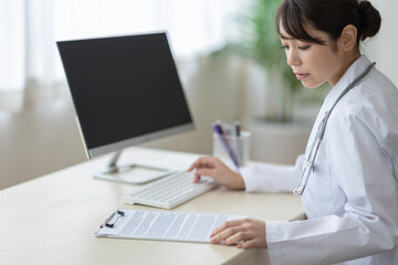 パソコンに入力する医師