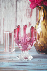 Decorative glass vase with pink accents on a rustic tabletop