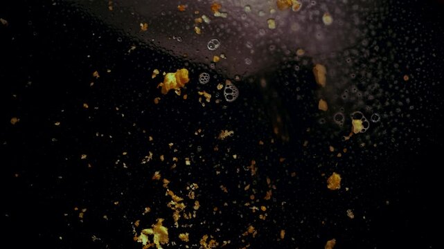 Spraying windex to clean orange crumbs.