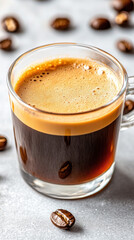 rich espresso with golden crema in clear glass cup, surrounded by coffee beans
