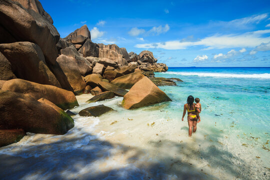 Asian woman with one year old child at the beach, Seychelles