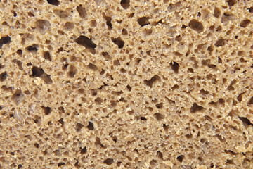 A Detailed Close-up of the Airy, Dense Crumb of a Rustic Dark Bread Loaf