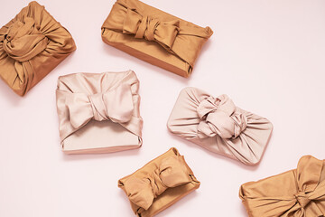 Fabric wrapped gifts, top view on light backdrop. Perfect for holidays, celebrations, and gift themes.