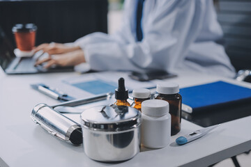 Positive doctor working on laptop in medical office, portrait.