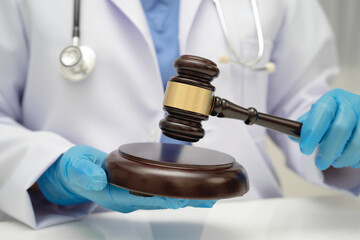 Asian doctor holding court hammer for and crime law justice, forensic medicine.