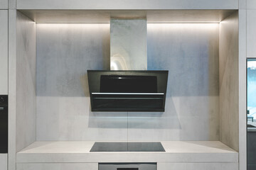 Elegant kitchen interior with modern range hood over Induction cooker. Interior of modern kitchen...