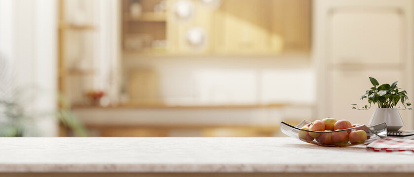 Minimalist white-marble kitchen island with decorative items set in in a minimalist, bright kitchen.