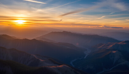 Aerial view of mountains and hills during golden sunset with blue skies and clouds