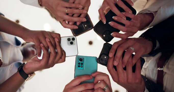 Networking, group and hands with smartphone, office and checking for competition on social media. Low angle, employees and people with mobile for project, content creator and teamwork for business