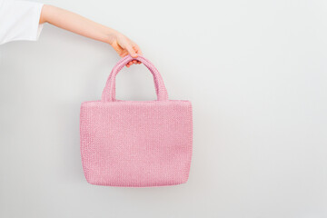 Pink empty beach bag in hand. Template for design, mockup. White background