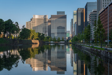 Skyscrapers of the Marunouchi business district in Chiyoda Ward with reflection in the Babasaki moat of the Tokyo Imperial Palace on a sunny day, Tokyo, Japan