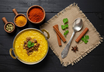 Hearty Indian Dal with Spices and Herbs on Rustic Black Wooden Background