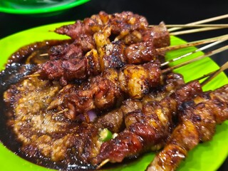 Succulent Sate Kambing skewers, grilled to perfection and served with a rich, savory sauce. A delightful treat for meat lovers