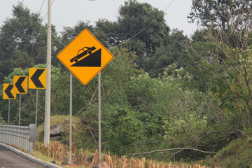 Dangerous slope sign is a traffic sign that warns drivers that the road has a steep slope in...