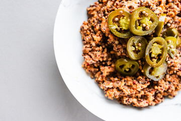 red pesto lentil quinoa topped with fresh jalapeno peppers