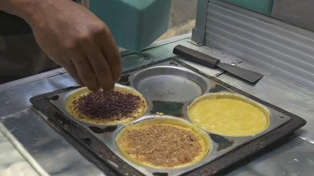the process of making Martabak mini (Terang Bulan), a typical Indonesian street snack topped with chocolate and cheddar cheese.