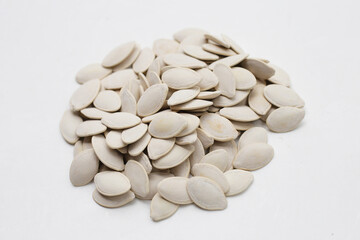 Roasted pumpkin seeds on white background.